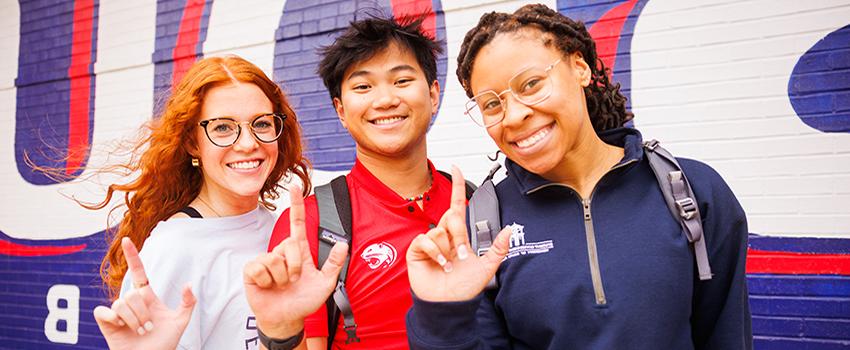 Three 南 Alabama students holding up the J sign for Jaguars.